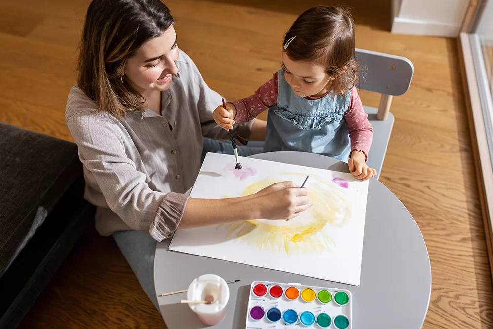 mother and preschooler coloring together
