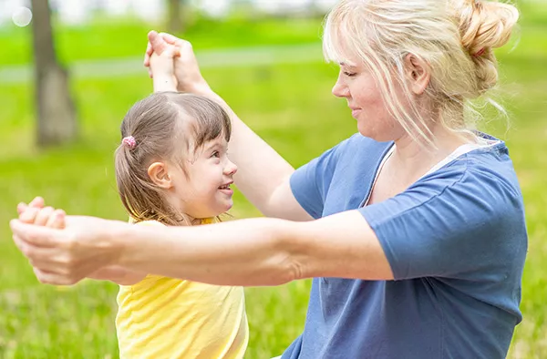 Little girl plays with her mother in a summer park.
