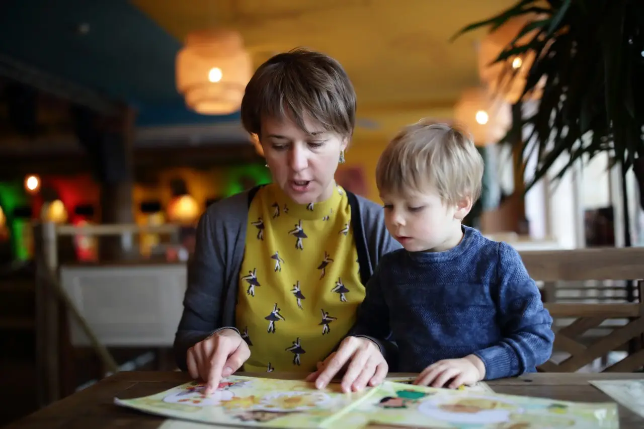 Mother and preschooler building problem solving skills by reading together and asking questions